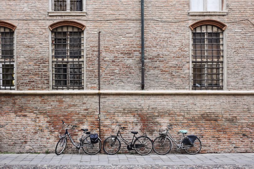 Una parete di un palazzo storico di Ferrara con le bici appoggiate